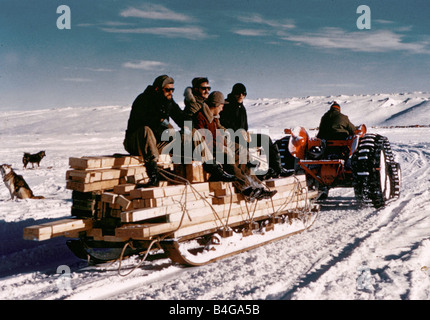 The Trans Antarctic Expedition 1956 1958 Members of the expedition team sit on top of a sledge laden with wood as a tractor pulls them throught the snow Explorers meet at South Pole Members of the team attempting the first surface crossing of the Antarctic have joined up at the South Pole New Zealander Sir Edmund Hillary who has already conquered Mount Everest arrived with his team 17 days ago Early this afternoon Sir Edmund welcomed the British team led by Dr Vivian Bunny Fuchs to the South Pole The British and New Zealand teams are members of a joint Commonwealth Trans Antarctic expedition Stock Photo