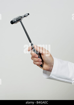 Human hand holding a reflex hammer Stock Photo