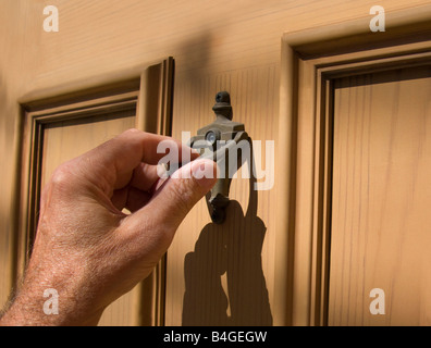 hand on brass door knocker Stock Photo