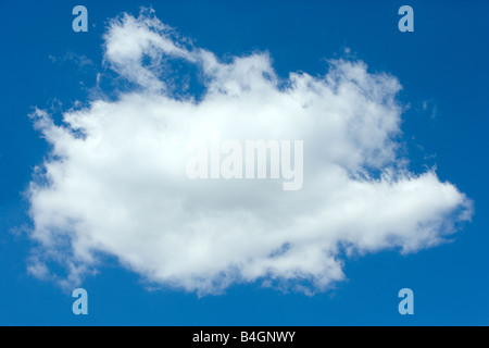 A single white cumulus cloud in a blue sky. Stock Photo