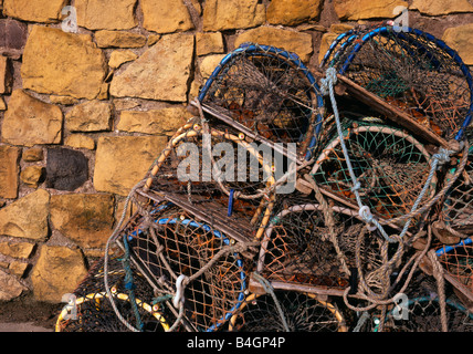 Beadnell, Northumberland, UK. Lobster pots stacked by the harbour in front of the lime kilns. Stock Photo