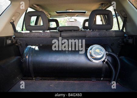 Rear of a 4x4 vehicle showing large 90 litre LPG tank in luggage compartment with actuator solenoid and connecting hoses UK Stock Photo