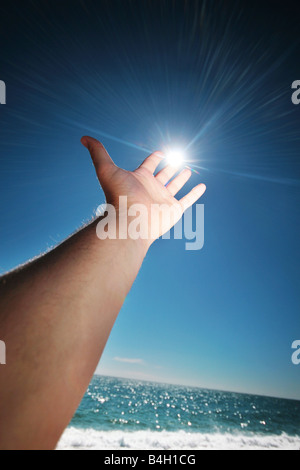 hand reaching the sun Stock Photo