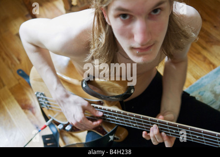 young bass guitar player looking up at camera Stock Photo