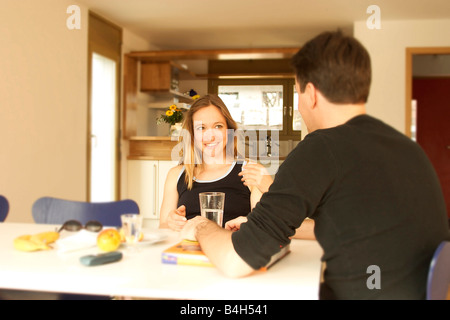 Young couple sitting at table and smiling Stock Photo