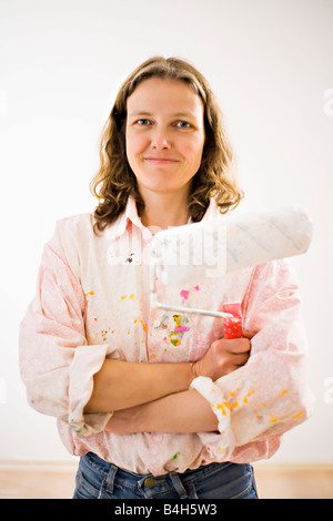 Portrait of woman holding paint roller Stock Photo