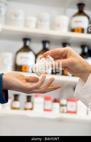 Pharmacist giving pill bottle to customer Stock Photo