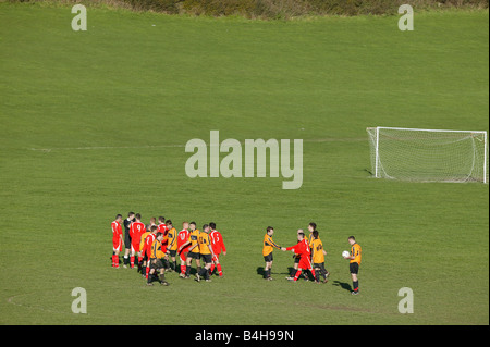 Two Sunday league football teams shake hands at the end of a game. Stock Photo