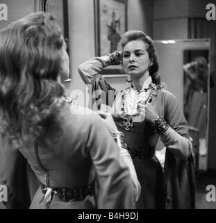Actress Janet Leigh looks at her reflection in the mirror at a costume fitting for the film The Vikings June 1957 Stock Photo