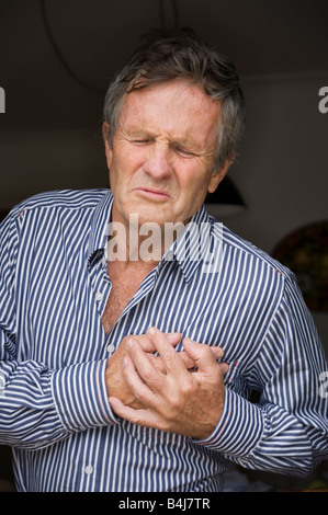 middle aged man clutching his heart Stock Photo