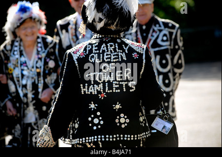 The London Pearly Kings & Queens Society: Back view of the Pearly Queen of Tower Hamlets walking towards fellow members. Stock Photo