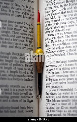 Vintage fishing float, nestled between the pages of old book on Angling. Stock Photo