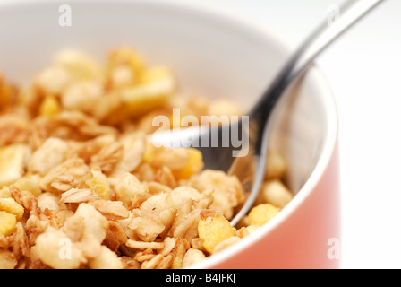 Healthy breakfast, spoon in a bowl of muesli. White background, selective focus, horizontal crop Stock Photo