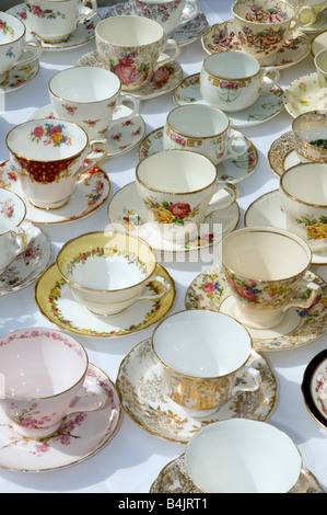 China cups and saucers laid out on white cloth covered table ready for tea party Stock Photo