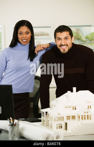 Multi-ethnic architects next to house model Stock Photo