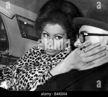 Carlo Ponti film producer has his cheek stroked by Sophia Loren actress and wife to be in back of limousine Stock Photo