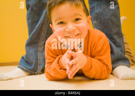 Mixed race boy laying on floor Stock Photo