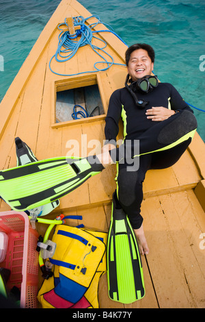 Asian man in scuba gear on boat deck Stock Photo