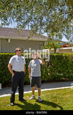 A county fire department inspector discusses the fire hazards of landscape plantings with a Southern California homeowner Stock Photo