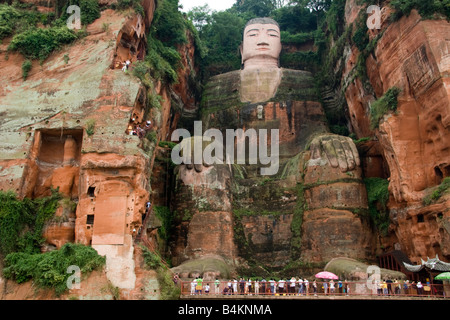 Tourists look up at the Giant Buddha of Leshan, China.  A UNESCO World Heritage Site Stock Photo