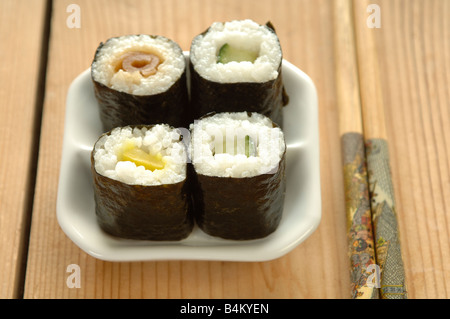 a small dish of sushi with chopsticks, vegetable or fish sushi at a restaurant or take away Stock Photo