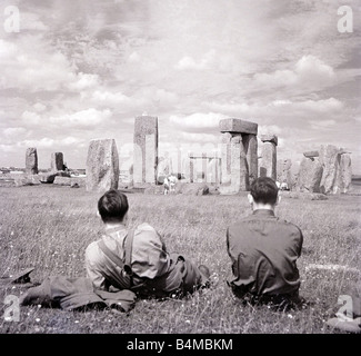 One of Britain s most famous and mysterious ancient monuments Stonehenge on Salisbury Plain Wiltshire Two men look at the monument where Druid pilgrims come to worship during the Summer Solstic Countryside Country Scene Scenic stones arranged in a circle Circa 1930 Stock Photo