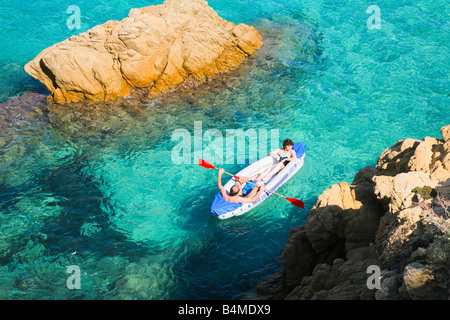 A rubber boat on the sea with rocks in the foreground Stock Photo - Alamy