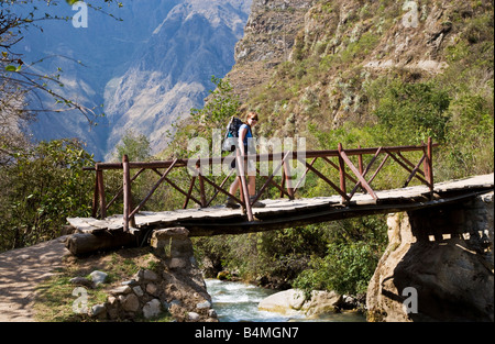 Trekker crossing footbridge over the Urubamba river on the Inca Trail through the Andes mountains of Peru on the first day one Stock Photo