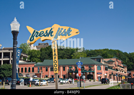 A sign for fresh fish and buildings in downtown Marquette Michigan Stock Photo