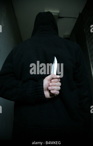 Man Hiding knife behind back Stock Photo