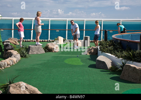 Cruise guests play miniature golf on the deck of the Royal Caribbean Navigator of the Seas cruise ship Stock Photo