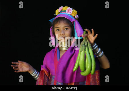 A young Longneck girl displays fresh fruit Approximately 300 Burmese refugees in Thailand are members of the indigenous group known as the Longnecks The largest of the three villages where the Longnecks live is called Nai Soi located near Mae Hong Son City Longnecks wear metal rings on their necks which push the collarbone down and extend the neck They are a tourist attraction Tourists visit Nai Soi to take pictures of the Longnecks and buy their handicrafts The villages are criticized by human rights organizations as human zoos Stock Photo