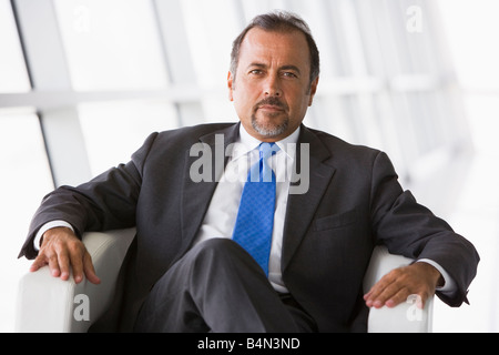 Businessman sitting indoors (high key/selective focus) Stock Photo