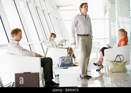 Male airline passenger waiting with other passengers in departure gate Stock Photo