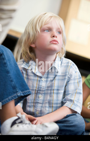 Student in class sitting on floor bored (selective focus) Stock Photo