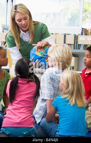 Teacher in class showing students a globe (selective focus) Stock Photo