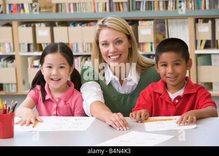 Two students in class with teacher Stock Photo