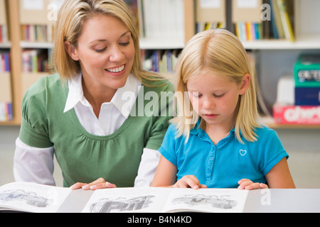 Student in class reading with teacher Stock Photo