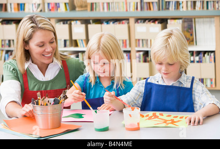 Two students in art class with teacher Stock Photo