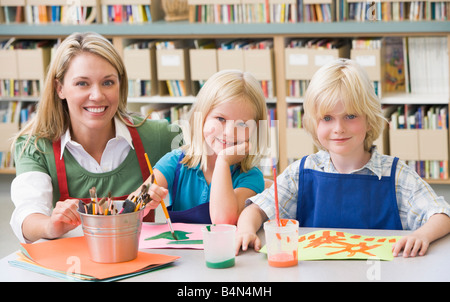 Two students in art class with teacher Stock Photo