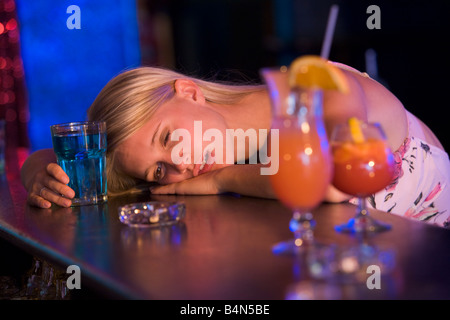 Drunk young woman passed out in bar Stock Photo