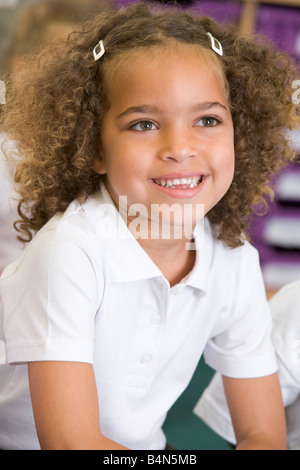 Student in class sitting on floor smiling (selective focus) Stock Photo