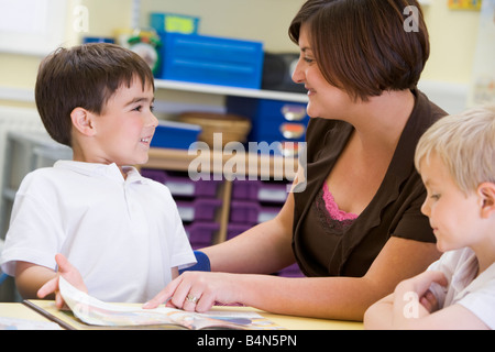 Students in class with teacher reading Stock Photo