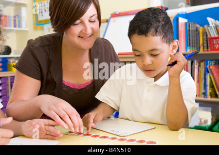 Student in class with teacher learning numbers Stock Photo
