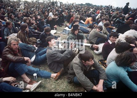 Music Pop Festivals Isle of Wight August 1969 Isle of Wight Pop Festival crowds of people sitted on the grass watching the bands play man with a telescope Stock Photo
