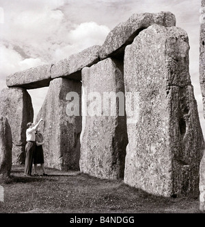 One of Britain s most famous and mysterious ancient monuments Stonehenge on Salisbury Plain Wiltshire a young couple look at the monument where Druid pilgrims come to worship during the Summer Solstice Stock Photo