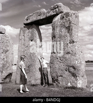 One of Britain s most famous and mysterious ancient monuments Stonehenge on Salisbury Plain Wiltshire a young couple look at the monument where Druid pilgrims come to worship during the Summer Solstic Stock Photo
