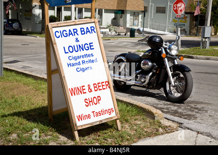 Motorcycle by a Cigar bar sign in small town America Stock Photo