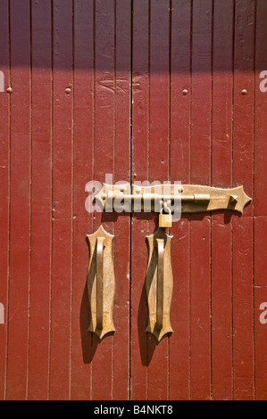 Red doorway with brass lock, padlock and handles on Hickson Road, The Rocks, Sydney, Australia Stock Photo