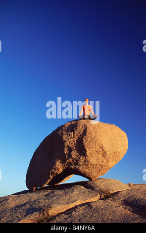 Algeria Djanet National Park Tassili n Ajjer UNESCO World Heritage site Woman meditating Sahara desert Stock Photo